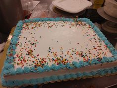 a birthday cake with blue frosting and sprinkles on the top is ready to be cut