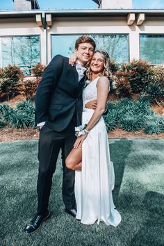 a bride and groom posing for a photo in front of a building