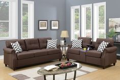 a living room with two couches and a coffee table in front of the windows