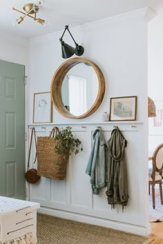 a room with a mirror, coat rack and other items on the wall in it