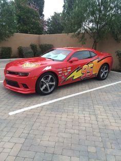 a red sports car with lightning bolt decals on it's side parked in a parking lot