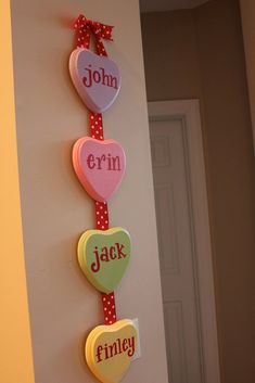 three hearts are hanging on the wall with names