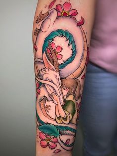 a woman's arm with tattoos on it and an image of a dragon in the middle