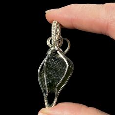 Moldavite from Chlum, South Bohemia, Czech Republic & sterling silver wire wrapped pendant. Please note that some photos have been backlit to show color and detail of the stone. All pendants come in a jewelry gift box with a small polishing cloth and black waxed cord included. Stone alone: 3.72 grams Completed pendant: 50 x 20 x 12 mm. 8 grams. Artisan Untreated Jewelry As Gift, Collectible Silver Wire Wrapped Jewelry, Hand Wrapped Teardrop Pendant Jewelry Gift, Untreated Round Pendant Jewelry Gift, Mineral Jewelry, Tourmaline Jewelry, Sterling Silver Wire Wrap, Wrapped Pendant, Wire Wrapped Pendant