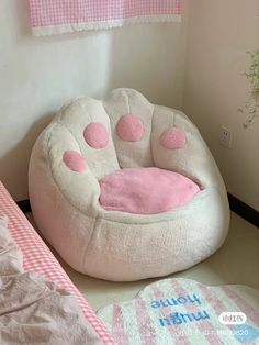 a pink and white cat bed sitting on top of a floor next to a window