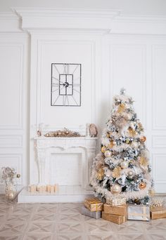 a decorated christmas tree in front of a fireplace