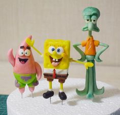 three spongebob figurines standing on top of a cake