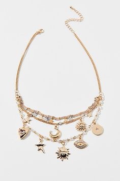 This gold-tone charm necklace layers on the charm with a triple-strand of celestial charms for an instant necklace stack look. Finished with an adjustable clasp. Features Celestial layered charm necklace Delicate gold metal chain necklace Tripled-layered for a necklace stack look Celestial charms include star charms, moons and more Silver metal star charm accents Adjustable length Content + Care Mixed metal Avoid contact with water Imported Size + Fit Dimensions: 16" l + extender | Celestial Lay Gold Necklace From Urban Outfitters As A Gift, Urban Outfitters Gold Necklace As A Gift, Gold Layered Charm Necklace Choker, Adjustable Multi-strand Gold Charm Necklace, Necklace Layers, Delicate Chain, Layering Necklace, Mixed Metals, Women Accessories Jewelry