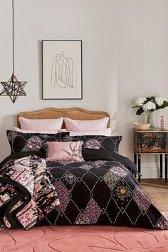 a bed with pink and black comforters in a room