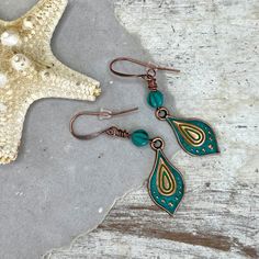 These beachy boho hand painted copper drop earrings are a unique and striking accessory that have been crafted in our island studio using a special house patina paint blend resulting in a beautiful palette reminiscent of the colorful folk art found in many beach-side Mexican villages. Once the patina process is complete, we buff and seal the copper for durability and to prevent tarnishing. Each pair of these earrings are one-of-a-kind, with variations in the patina that add to their handmade charm. We have paired them with vintage style matte glass balls with a copper wash for added sway and spunk! Color: Antique Copper  Size: 2.25 Inches from Lobe Ear Wire: Choice of Antique Copper or Sterling Silver French Ear Hooks with Safety Back Lightweight and Comfortable Handmade in the USA Gift Re Bohemian Teardrop Jewelry With Artistic Design, Adjustable Bohemian Earrings With Artistic Design, Bohemian Bronze Hypoallergenic Earrings, Artsy Green Earrings For Festival, Bohemian Hypoallergenic Bronze Earrings, Hypoallergenic Bohemian Bronze Earrings, Handmade Bohemian Teardrop Earrings For Beach, Bohemian Handmade Teardrop Earrings For Beach, Green Hand-painted Bohemian Earrings