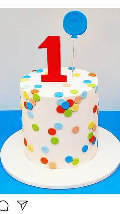 a birthday cake decorated with confetti and a number one on top is shown