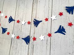 red, white and blue paper airplanes are arranged on a wood background with stars in the shape of an arrow