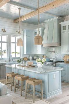 a large kitchen with blue cabinets and white counter tops is pictured in this image, there are four stools at the center of the island