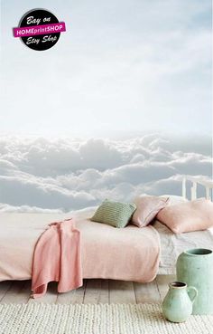 there is a bed with pink sheets and pillows on the floor next to a vase