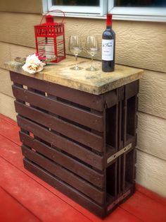 a wine bottle sitting on top of a wooden crate next to a glass filled with wine