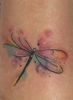 a tattoo with a dragonfly on it's side ribcage, and watercolor