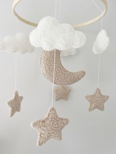 a crocheted mobile with stars and clouds hanging from it