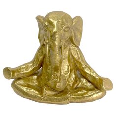 an elephant statue sitting in the middle of a meditation pose with its trunk up and eyes closed