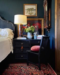 a bedroom with a bed, desk and chair in it's corner next to a mirror