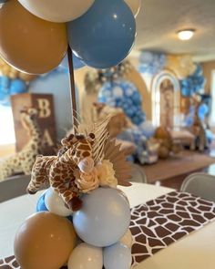 a table topped with balloons and giraffes on top of eachother