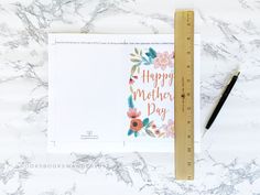 a card with the words happy mother's day on it next to a ruler