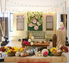 a living room filled with lots of furniture and flowers on top of a wooden table