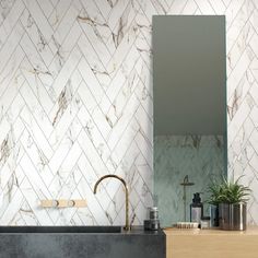 a bathroom with marble walls and flooring next to a black sink in front of a mirror