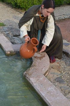 a woman is pouring water into a pot