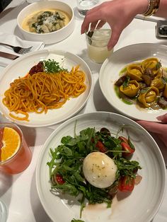 three plates of food on a table with utensils and drinks in front of them