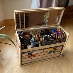 a wooden box filled with lots of art supplies