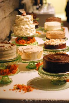 a table topped with lots of cakes covered in frosting