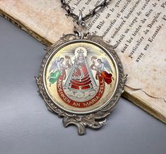 A beautiful genuine antique Austrian Catholic medal, rare solid silver red enamel Maria Zell medal, depicting Madonna and Child with angels, beautiful engravings, and ancient enamel work. Nice size, a stunning keepsake, would make a nice gift for someone special! Floats from an antique 26-inch long silver chain. Material: solid silver, enamel Total weight (with chain): 29.7 g Medal measures: approx. 40 mm (1.6 inch) in diameter Box on photos is NOT included! PLEASE LOOK AT THE PICTURES, THEY ARE Silver Intaglio Round Pendant Necklace, Silver Necklace With Intaglio Round Pendant, Engraved White Gold Jewelry For Commemoration, Antique Jewelry With Miraculous Medal For Collectors, Antique Engraved Enamel Necklace, Antique Silver Enamel Necklace, Antique Silver Enamel Necklaces, Silver Medallion Necklace Souvenir, Silver Medallion Necklace As Souvenir