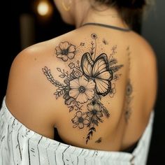 a woman with a butterfly tattoo on her back shoulder and flowers around the neck,