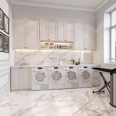 a laundry room with washers, dryer and cabinets in white marbled flooring