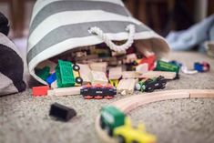 a pile of toys sitting on top of a floor next to a pillow and blanket