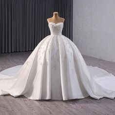 a wedding dress on display in front of a curtain