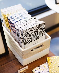 a stack of papers sitting on top of a wooden table next to a window in a room