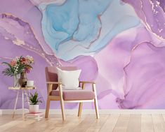 a chair sitting in front of a purple and blue wall mural with white paint on it