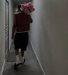 a person walking down a hallway with flowers on their head