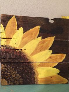 a painted wooden sign with a sunflower on it