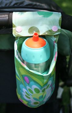 a baby stroller with a bottle holder attached to it's handlebars