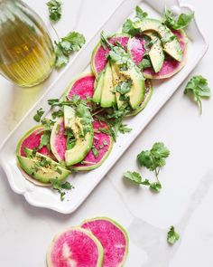 slices of watermelon and avocado with cilantro on a platter