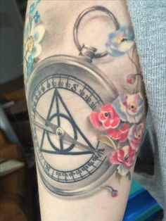 a close up of a person's arm with a tattoo on it and flowers