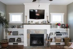 a living room filled with furniture and a flat screen tv mounted above a fire place