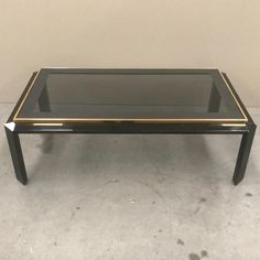 a black and gold coffee table with glass top