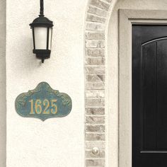 a black door with a light on it and a sign that says 1265 above the door