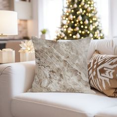 a living room with a white couch and christmas tree in the backgroung