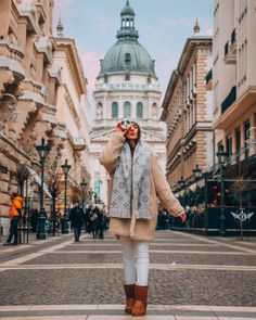 a woman standing in the middle of an empty street with her hands up to her face