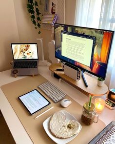 a desk with a laptop, monitor and keyboard on it next to a tablet computer