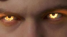 the eyes of a man with glowing yellow irises on his face are shown in this close up photo